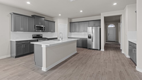 Open concept kitchen with stainless steel appliances, shaker style cabinets, and elevated finishes