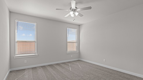Primary bedroom with plush carpet floors and views of the backyard