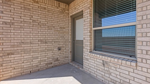 Covered back patio area overlooking spacious backyard