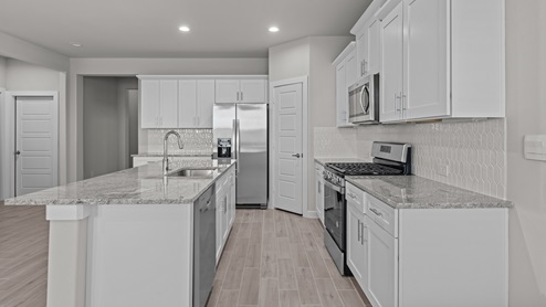 White kitchen with stainless steel appliances and stylish backsplash