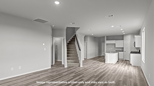 Downstairs kitchen, living, and family room space with staircase