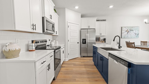 Coastal kitchen in the Dover with white and blue cabinets.
