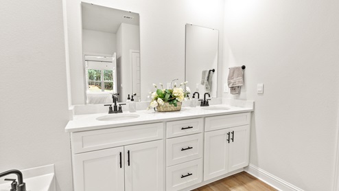 Double vanity with white cabinets and black fixtures in a coastal cottage on the MS Gulf Coast.