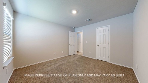 Seabrook secondary bedroom with carpet flooring and windows.