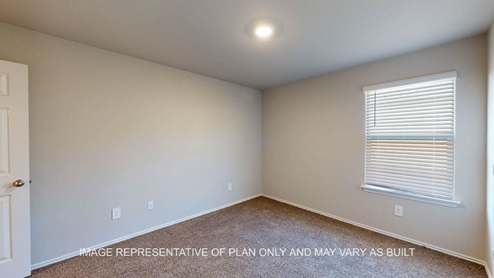 Texas Cali secondary bedroom with carpet flooring and window.