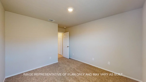 Texas Cali primary bedroom with carpet flooring and door back into hallway.