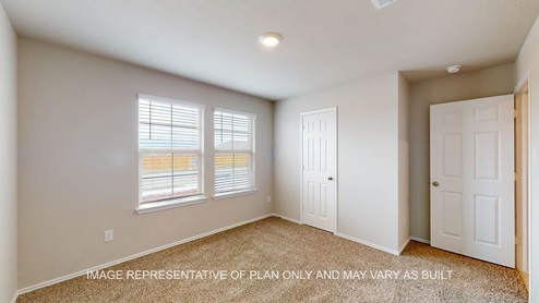 Texas Cali secondary bedroom with carpet flooring and windows.