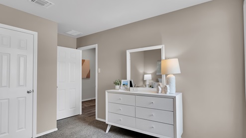 Cedar trails model home secondary bedroom with carpet flooring and light painted wall and neutral accents