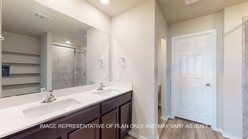 Fargo primary bath with dark cabinets and white countertops.