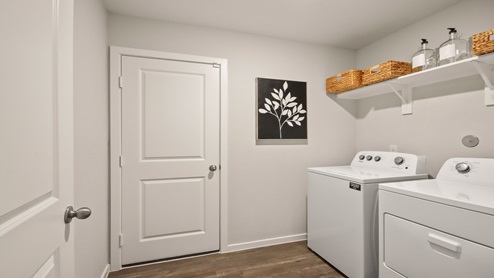 Laundry room with white walls and vinyl wood flooring.