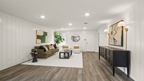 Open living room with windows, white walls, and vinyl wood flooring.