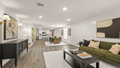 Open living room with windows, white walls, and vinyl wood flooring.