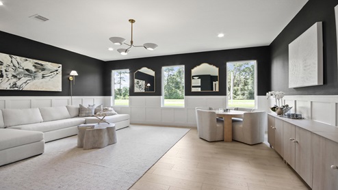 Large game room with windows, white walls, and light vinyl wood flooring.