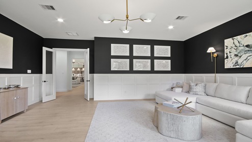 Large game room with windows, white walls, and light vinyl wood flooring.