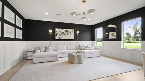 Large game room with windows, white walls, and light vinyl wood flooring.