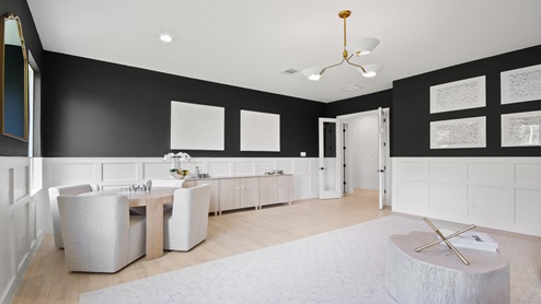 Large game room with windows, white walls, and light vinyl wood flooring.