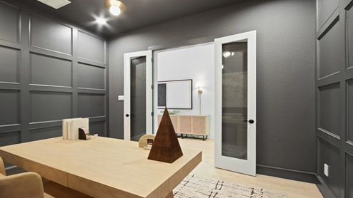 Study with double doors, white walls, and light vinyl wood flooring.