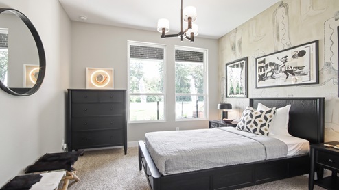 Secondary bedroom with windows, white walls, and light carpet.