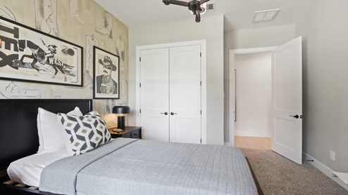 Secondary bedroom with windows, white walls, and light carpet.
