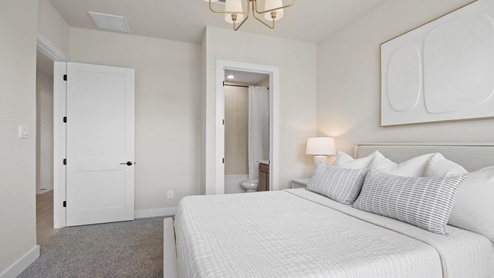 Secondary bedroom with windows, white walls, and light carpet.