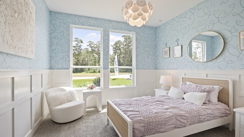 Secondary bedroom with windows, white walls, and light carpet.