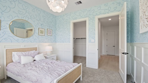 Secondary bedroom with windows, white walls, and light carpet.