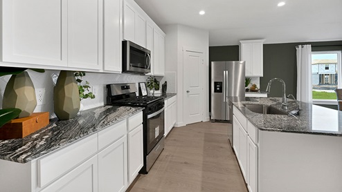 kitchen with white cabinets and waterfall countertops
