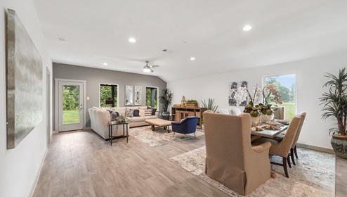 Holly Trails model home dining room with view of the living room and back door.