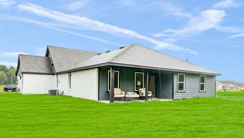 Holly Trails model home backyard with a view of the back door and patio.