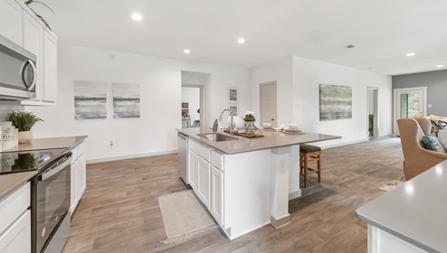 Holly Trails model home kitchen with white cabinets and granite countertops.