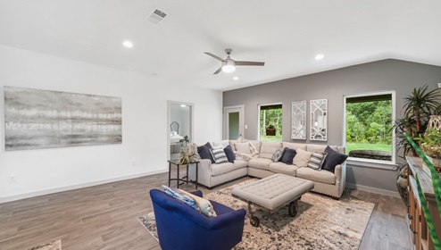 Holly Trails model home living room with a view of the back door and backyard.