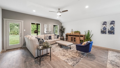 Holly Trails model home living room with a view of the back door and backyard.