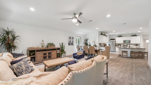 Holly Trails model home living room with open concept of the dining room and kitchen.