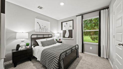 China Grove model home secondary bedroom with black and white decorative accents.