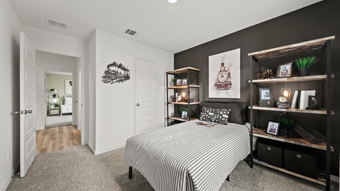 China Grove model home secondary room with carpet flooring and dark accent wall and shelving.