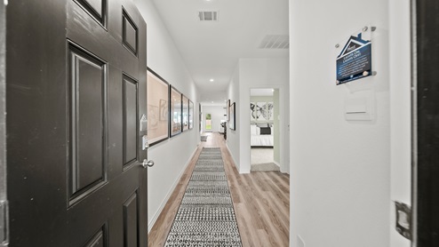 China Grove model home entry with long hallway and vinyl plank flooring.