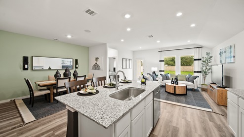 China Grove model home full view of kitchen, dining and living room with vinyl plank flooring throughout.