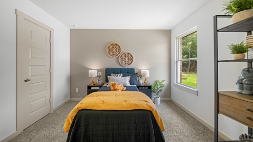 Windemere model home secondary bedroom with a twin-size bed and carpet flooring.