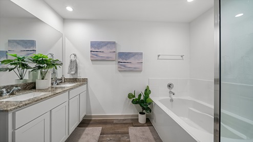 Windemere model home primary bathroom with soaking bathtub and double vanity sinks.