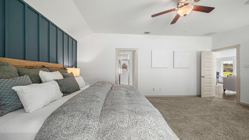 Windemere model home primary bedroom with a king bed and view of the primary bathroom.