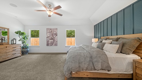 Windemere model home primary bedroom with a king bed and carpet flooring.