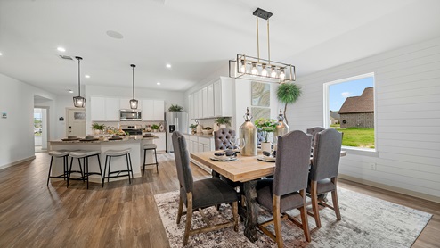 Windemere model home dining room with view of the kitchen and the front door.