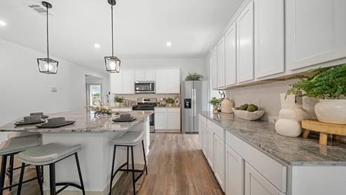 Windemere model home kitchen with white cabinets and granite countertops.