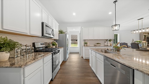 Windemere model home kitchen with white cabinets and granite countertops.
