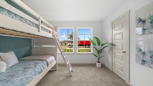 Windemere model home secondary bedroom with twin bunk beds and carpet flooring.