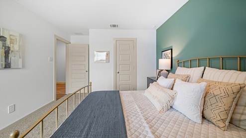 Windemere model home secondary bedroom with a full-size bed and view of the closet door.