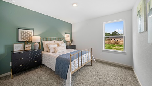 Windemere model home secondary bedroom with a full-size bed and carpet flooring.