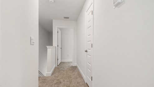 Second level landing and hallway with carpet
