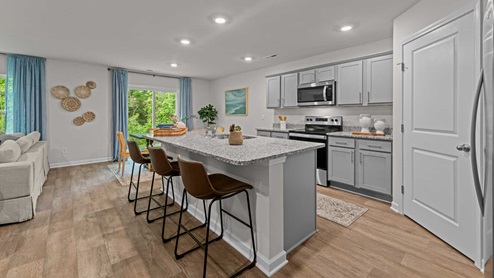 Open kitchen area with island and granite countertops with stainless steel appliances
