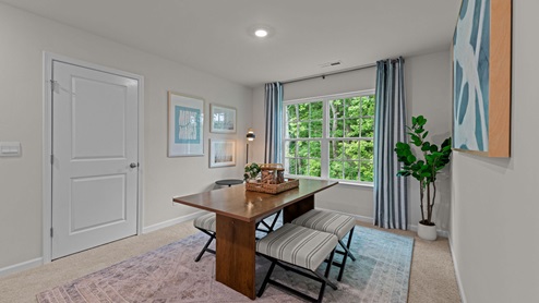 Upstairs loft area with carpet flooring and large window